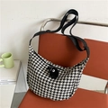 Borsa a tracolla pied-de-poule bianca e nera con ciondolo in peluche su una sedia arancione - Bianco e Nero (Con Pallina di Peluche)