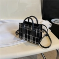 Chic black and white plaid tweed handbag with leather handles and gold metal accents - Black