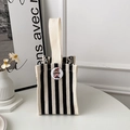 Minimalist black and white striped canvas tote bag with a round cartoon badge detail - Black