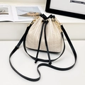 Minimalist straw bucket bag in cream white with black leather trim and drawstring closure - Black