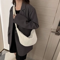 Sac bandoulière blanc minimaliste en forme de croissant porté avec un blazer gris chic - Sans pendentif / Blanc Cassé
