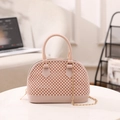Pink jelly shell handbag with textured bead design and gold chain strap on white table - Apricot