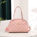 Pink quilted handbag with gold metal plate and detachable strap on white table - Pink
