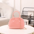 Sac à main en gelée rose avec texture perlée et chaîne dorée dans un intérieur cosy - Rose