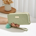 Long double zipper wallet in sage green with geometric quilting and pompom detail - Green