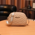 Bolso bandolera beige minimalista con bordado ondulado y correa ancha sobre madera - Caqui