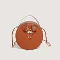 Classic round brown leather shoulder bag with woven texture and gold flamingo charm - Brown