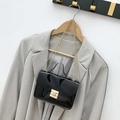 Borsa a tracolla minimalista in vernice nera con catena dorata su blazer grigio - Nero