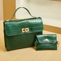 Sac à main vert émeraude à motif crocodile avec garniture dorée sur table en bois - Vert