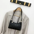 Bolso de hombro acolchado negro con adorno dorado colgado en una percha de madera - Negro