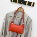 Bolso de hombro estilo baguette naranja acolchado con detalles dorados en una percha - Rojo