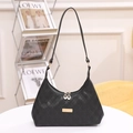 Chic black quilted shoulder bag with gold hardware and embroidery on a white table - Black Quilted Pattern