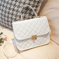 Borsa a tracolla trapuntata bianca con chiusura girevole dorata su cuscino beige - Bianco