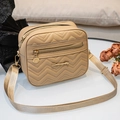 Beige V-quilted crossbody bag with wide fabric strap and metallic circular pendant charm - Khaki