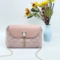 Pink quilted crossbody bag with pearl cat ears buckle and gold chain strap in a still life view - Pink