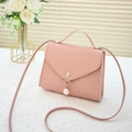 Pink woven texture small crossbody bag featuring V-shaped flap and pearl pendant detail - Pink