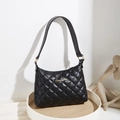 Bolso de hombro acolchado negro con logotipo dorado sobre bandeja de madera - Negro