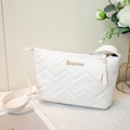Witte schoudertas met chevron-stiksel en gouden logo op een elegante achtergrond - Wit