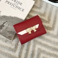Elegant red PU leather tri-fold wallet with a golden bow metal clasp and stylish white trim - Red