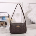 Deep brown underarm bag with chevron quilting and golden metal accent on marble top - Coffee