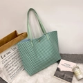 Muntgroene shopper met zwarte cirkelprint en slanke handvatten op wit pluchen tapijt - Groen