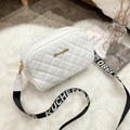 Quilted white camera bag with gold logo and contrast woven strap on white plush background - White