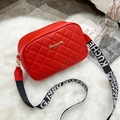 Elegant red quilted camera bag for women with a wide jacquard strap on a plush rug - Red