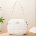 Elegante weiße Stepp-Schultertasche mit Goldlogo auf warmem Holztisch-Hintergrund - Weiß