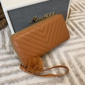 Caramel quilted long wallet with V-pattern stitching and fluffy pompom charm strap - Brown