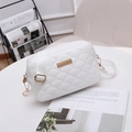 White quilted crossbody bag with golden hardware and adjustable strap on a white table - White