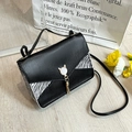 Black lizard texture crossbody bag with zebra print and golden cat tassel charm - Black