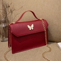 Mini burgundy crossbody bag with white butterfly clasp and gold chain strap detail - Red