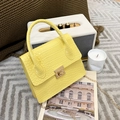 Yellow crocodile pattern handbag with gold chain strap on minimalist background - Yellow