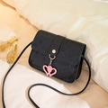 Black embossed leather crossbody bag with cartoon motifs and pink heart charm decoration - Black