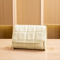 Quilted crossbody bag in cream leather with gold chain strap on wooden surface - Light Gray