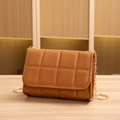 Brown quilted shoulder bag with gold chain strap on a wooden surface - Brown