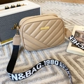 Beige quilted crossbody bag with wide letter-printed strap on a textured gray background - Khaki