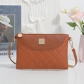 Brown quilted crossbody bag with diamond stitching and golden hardware on white fabric - Brown