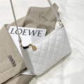 Sac à bandoulière matelassé blanc avec détails dorés posé sur un blazer et magazine - Blanc