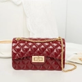 Deep red silicone jelly bag with quilted pattern and gold chain strap in elegant setting - Red
