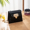 Mini black jelly shoulder bag with gold chain and leaf lock on a wooden table - Black