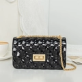Women's black quilted jelly crossbody bag with gold chain and metal lock closure - Black