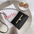 Mini black crossbody bag with crocodile pattern and golden metal buckle on a magazine - Black