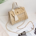 Woven straw crossbody bag with cream leather flap and gold chain strap in a 45-degree view - White