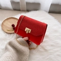 Mini red sequin chain bag with gold flip lock shown on a white plush background - Red