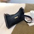 Chic black crocodile pattern underarm bag with gold metal plate on a cozy home background - Black