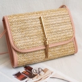 Pink straw crossbody handbag with woven texture, metal tassel, and gold-tone buckle closure - Pink