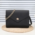 Bolso bandolera negro con textura de grano, cadena dorada y cierre de giro elegante - Negro