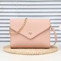 Chic pink leather shoulder bag with gold chain strap and turn-lock closure on woven mat - Pink