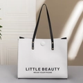 White faux leather tote bag with black Little Beauty print and long shoulder straps - White